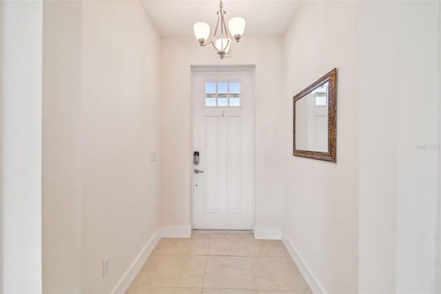 entryway featuring light tile patterned floors, baseboards, and a notable chandelier