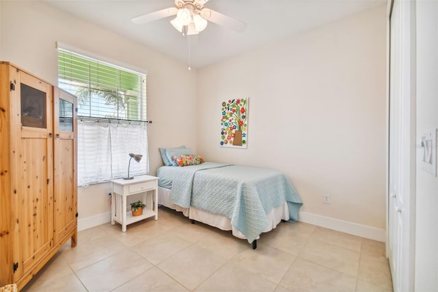 bedroom with light tile patterned flooring, a ceiling fan, and baseboards