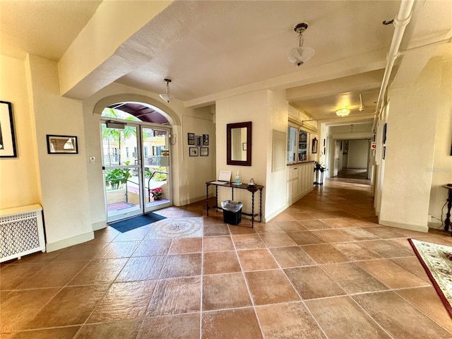 entryway featuring radiator heating unit and baseboards