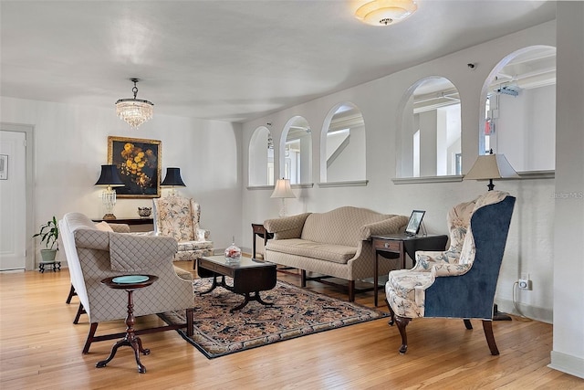 living room with wood finished floors and arched walkways