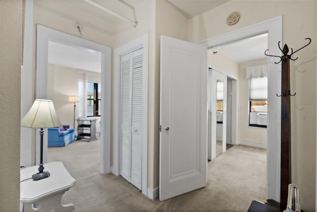 corridor with carpet flooring and baseboards