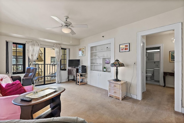 carpeted living room with built in features, baseboards, and a ceiling fan