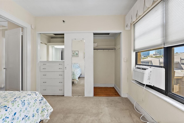 carpeted bedroom with cooling unit, baseboards, and a closet