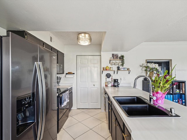 kitchen featuring light countertops, stainless steel appliances, light tile patterned flooring, a textured ceiling, and a sink