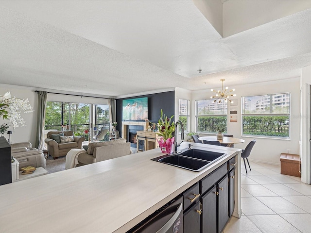 kitchen featuring a wealth of natural light, open floor plan, light countertops, and a sink