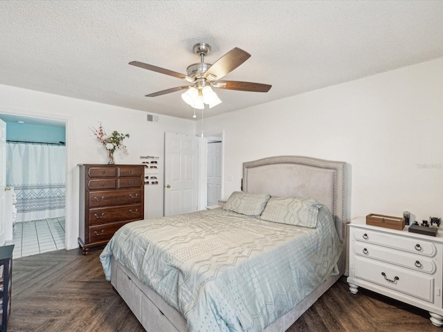 bedroom featuring visible vents, ensuite bath, a closet, a textured ceiling, and a ceiling fan