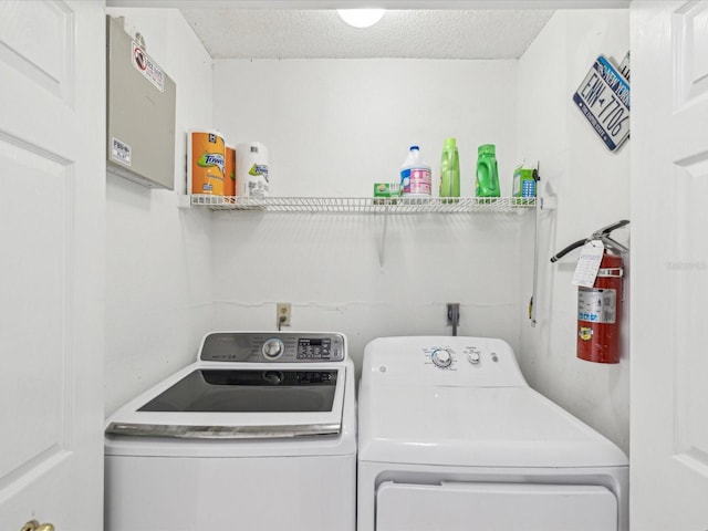 laundry area featuring washing machine and clothes dryer, laundry area, and a textured ceiling