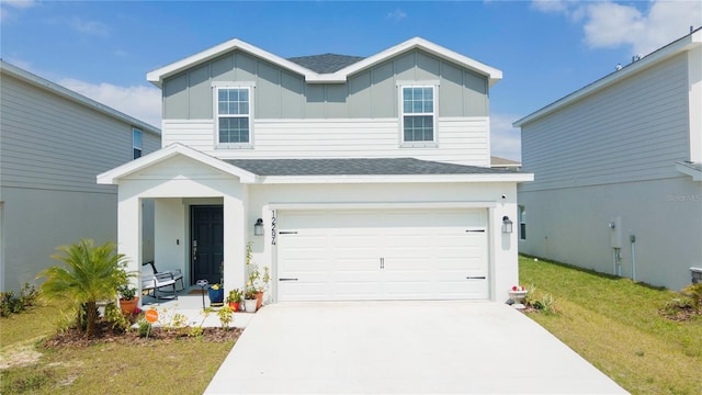 traditional home featuring an attached garage, board and batten siding, driveway, and a shingled roof