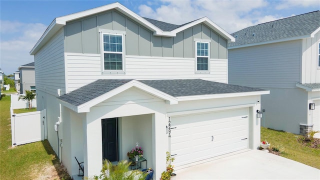 view of front of home with a garage, board and batten siding, driveway, and roof with shingles