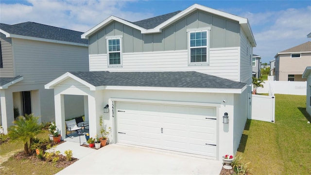 view of front of house featuring board and batten siding, a shingled roof, a garage, and fence