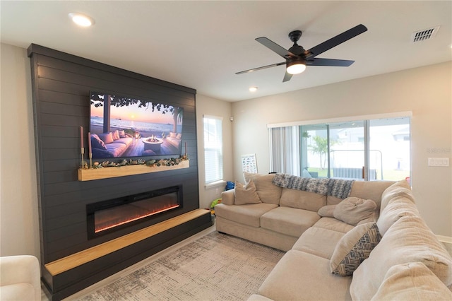 living room with visible vents, plenty of natural light, a fireplace, and ceiling fan