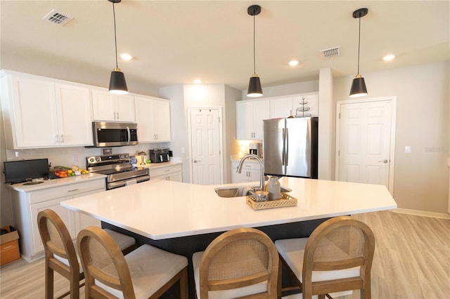 kitchen featuring a sink, white cabinets, visible vents, and stainless steel appliances