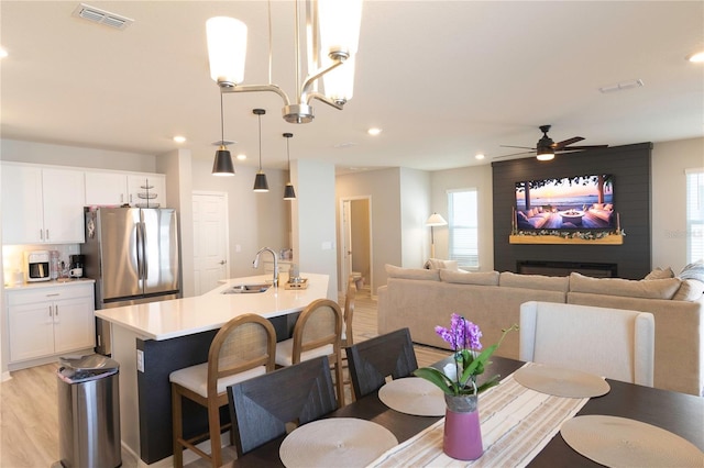 dining area featuring recessed lighting, visible vents, light wood-style floors, and ceiling fan with notable chandelier