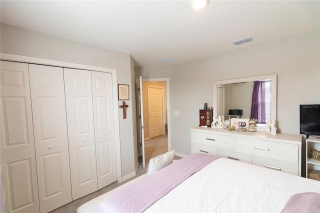 carpeted bedroom with a closet, visible vents, and baseboards