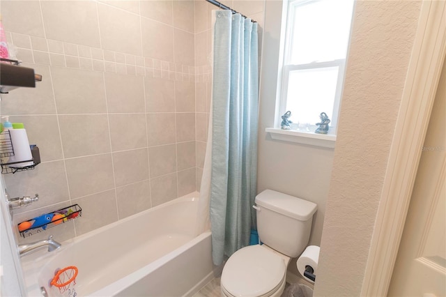 full bathroom with toilet, shower / bath combo with shower curtain, and a textured wall