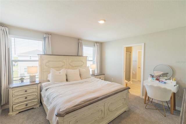 bedroom featuring multiple windows, ensuite bathroom, and baseboards