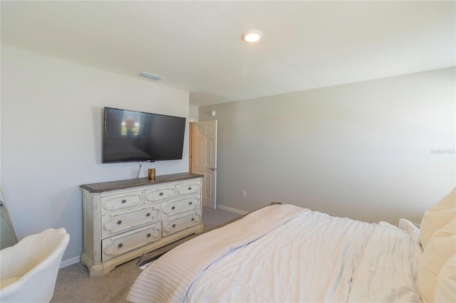 bedroom with baseboards, visible vents, and light carpet