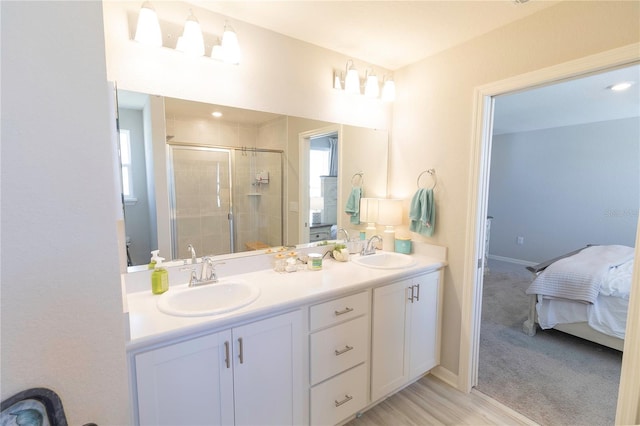 ensuite bathroom with double vanity, a stall shower, ensuite bath, and a sink