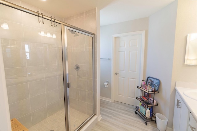 full bathroom with vanity, wood finished floors, and a stall shower