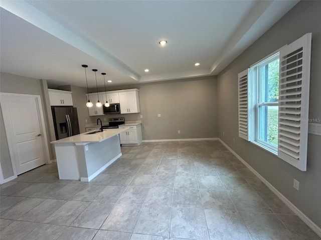 kitchen featuring baseboards, light countertops, a tray ceiling, recessed lighting, and stainless steel appliances