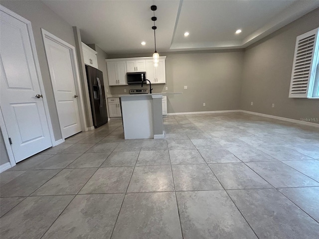 kitchen featuring stainless steel microwave, baseboards, black fridge with ice dispenser, and open floor plan