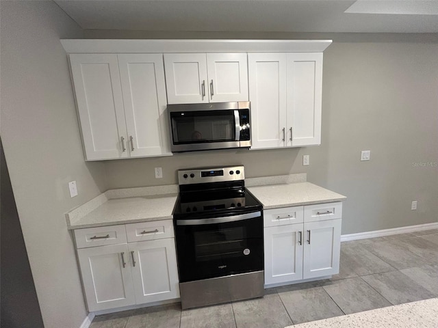 kitchen featuring white cabinetry, baseboards, and stainless steel appliances