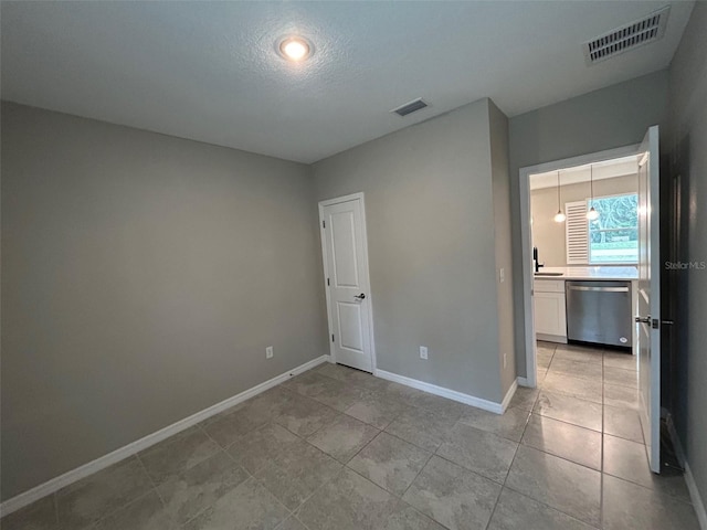 spare room featuring light tile patterned floors, baseboards, visible vents, and a sink