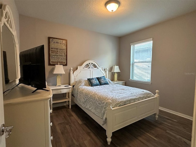 bedroom featuring dark wood finished floors and baseboards