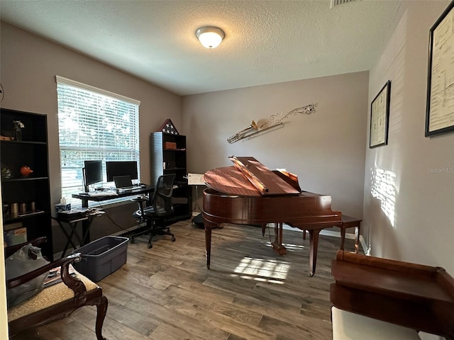 home office featuring baseboards, a textured ceiling, and wood finished floors