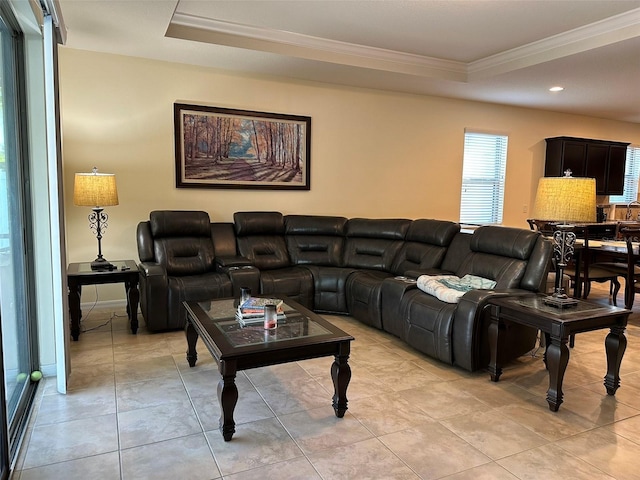 living room featuring light tile patterned floors, a raised ceiling, and crown molding