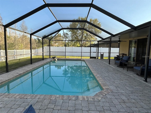 view of swimming pool with glass enclosure, a patio, and a fenced backyard