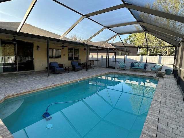 view of pool featuring a fenced in pool, fence, glass enclosure, a patio area, and a ceiling fan