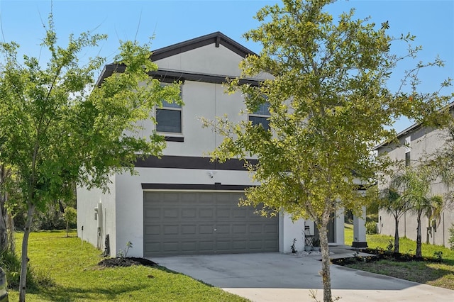 view of front of home featuring a front yard, a garage, driveway, and stucco siding