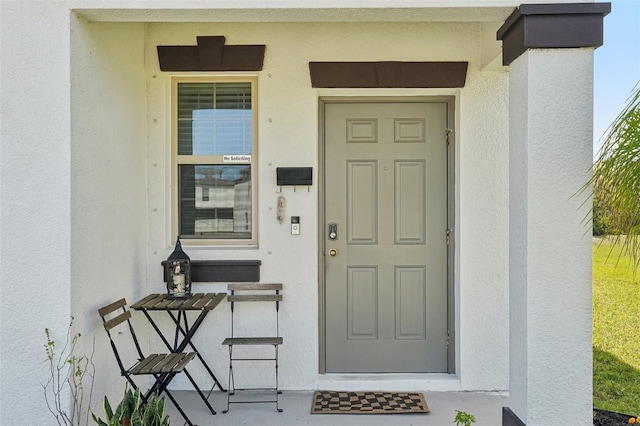 doorway to property featuring stucco siding