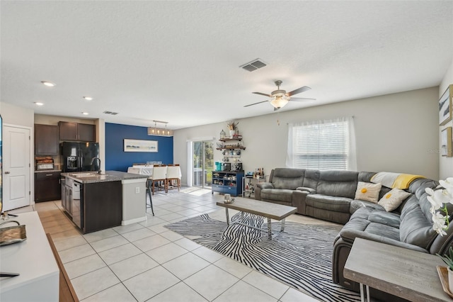 living room with visible vents, a textured ceiling, recessed lighting, light tile patterned floors, and ceiling fan