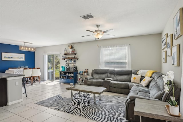 living room with light tile patterned floors, visible vents, ceiling fan with notable chandelier, and track lighting