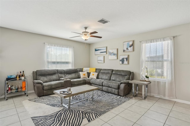 living area with ceiling fan, visible vents, baseboards, and light tile patterned flooring