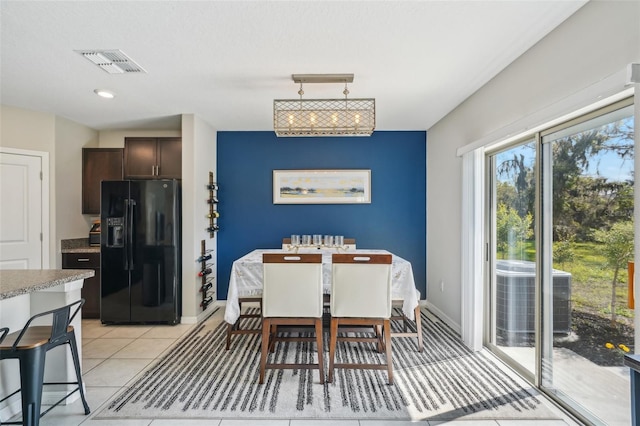 dining room featuring light tile patterned floors, baseboards, and visible vents