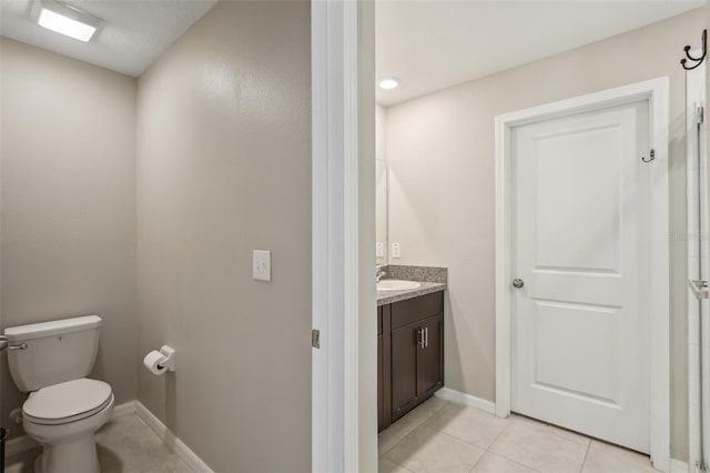 bathroom with tile patterned floors, toilet, vanity, and baseboards