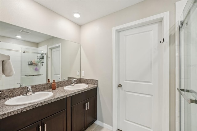 full bathroom featuring double vanity, visible vents, a stall shower, and a sink