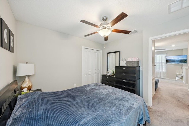 carpeted bedroom with baseboards, visible vents, a closet, and ceiling fan