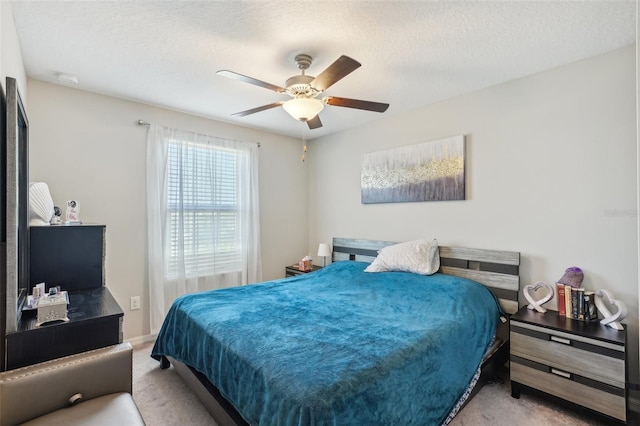 bedroom with a ceiling fan, a textured ceiling, and carpet flooring