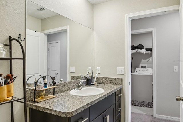 bathroom featuring visible vents, washer / dryer, and vanity