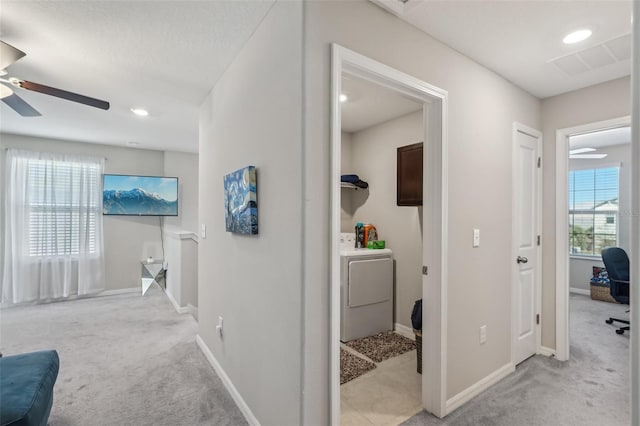 corridor featuring a wealth of natural light, carpet flooring, and washer / clothes dryer