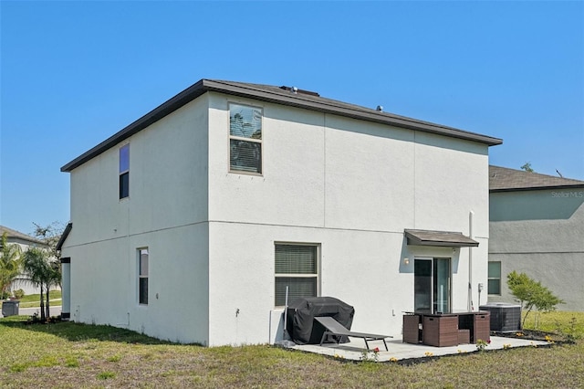 rear view of property with central AC unit, a lawn, a patio, and stucco siding