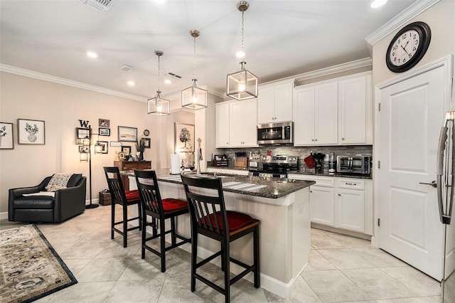 kitchen with a breakfast bar area, a sink, stainless steel appliances, crown molding, and backsplash