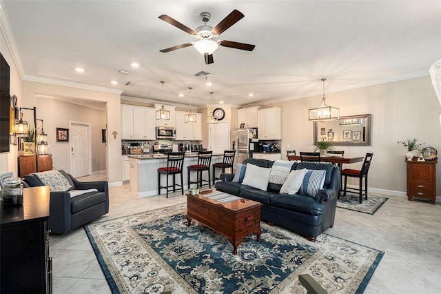 living area featuring baseboards, visible vents, recessed lighting, ornamental molding, and ceiling fan