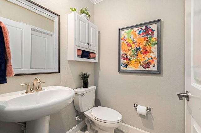 bathroom with toilet, baseboards, and a sink