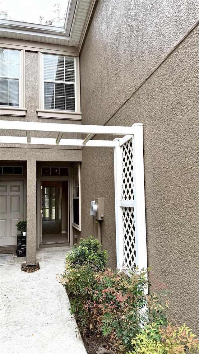 view of exterior entry featuring stucco siding