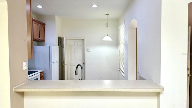 kitchen with white appliances, recessed lighting, light countertops, and pendant lighting